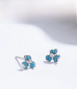 Macro shot of S925 silver iris flower earrings with blue enamel and zircon detail