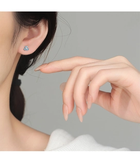Detail shot of light blue enamel iris flower earrings with a central white cubic zirconia