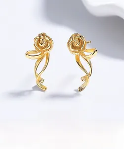 Detailed view of elegant gold rose stud earrings with flowing ribbon stems for women