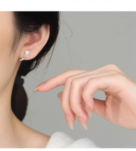 Close-up of elegant S925 silver rose flower stud earring worn on ear with leaf detail