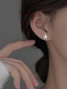 Detail of a 925 sterling silver maple leaf stud earring with brushed metal finish