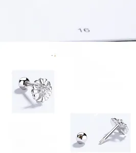 Close-up of a 925 sterling silver floral cross stud with a central zircon and screw back