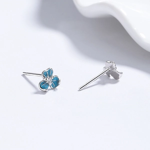 Elegant S999 silver iris earrings with blue enamel petals and center zircon stone