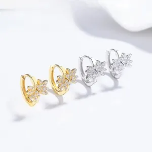 Close-up of 925 silver leaf hoop earrings with micro-set zircons in gold and silver