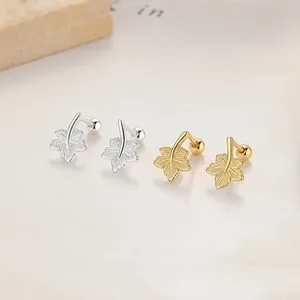 Detailed macro view of leaf earrings with gold and silver finishes and screw-back closure