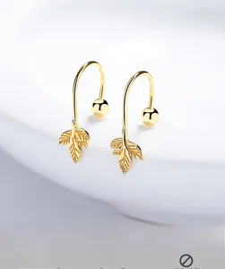 Macro shot of gold-plated 925 silver maple leaf earrings with intricate leaf vein details