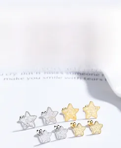 Detailed macro view of S925 silver star earrings with gold and silver plated finish
