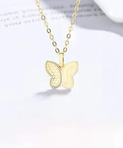 Vue macro d'un collier papillon asymétrique doré avec texture effet glace et fini poli