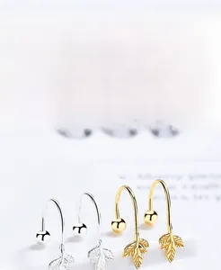 Macro shot of S925 silver maple leaf U-shaped earrings in silver and gold plating