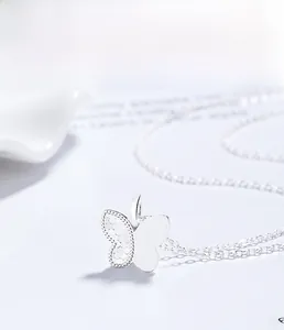 Gros plan du pendentif papillon en argent 925 avec texture alvéolée et finition polie
