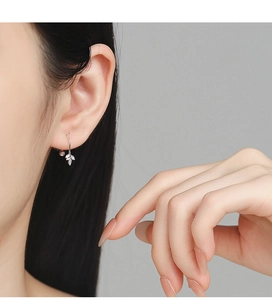 Macro view of 925 silver maple leaf earrings with detailed veins on a female model