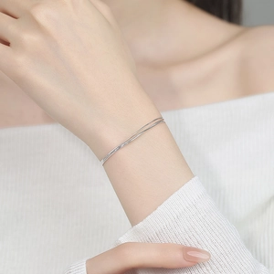 Minimalist double-layered silver snake chain bracelet for women on a model wrist