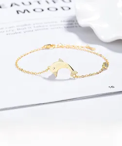 Detail of gold dolphin pendant bracelet with LOVE engraving and sparkling zircon stone