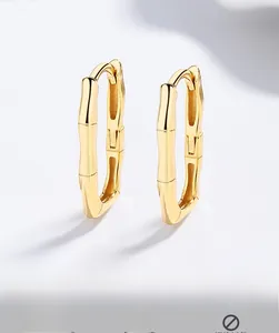 Close-up of golden bamboo hoop earrings with polished finish and hypoallergenic silver hooks