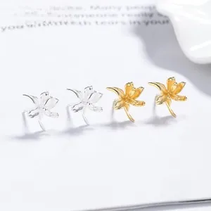 Detailed view of 925 silver and gold flower earrings with zircon on a white background