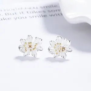 Macro shot of 925 silver cherry blossom studs with golden stamen and frosted petals