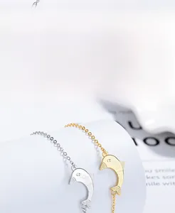 Macro detail of S925 sterling silver dolphin charms with LOVE engraving in gold and silver