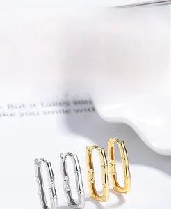 Macro detail of S925 sterling silver bamboo textured hoop earrings in gold and silver