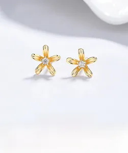 Macro view of S925 silver flower studs with gold plating and center cubic zirconia