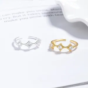 Detailed close-up of adjustable silver and gold rings featuring three diamond-cut zircons