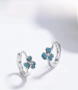 Détail macro de boucles d'oreilles iris en argent 925 avec émail bleu et zircon