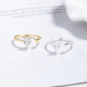 Macro detail of silver and gold open rings featuring pear-cut zircon flower stones