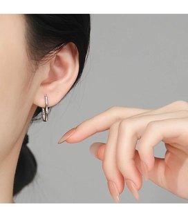 Close-up of 925 silver bamboo-style hoop earrings worn by a model for a chic look