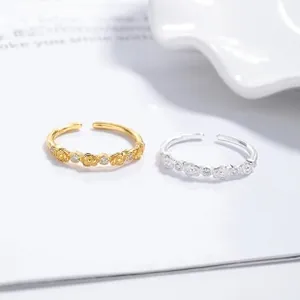 Detailed view of floral open rings in gold and silver finish with zircon accents