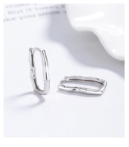 Macro detail of S925 sterling silver bamboo hoop earrings with hallmark engraving