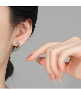 Détail de boucles d'oreilles iris en argent 925 avec émail bleu clair et zircon