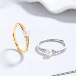 Detail of adjustable 925 silver pearl rings in gold and silver finish with small zircons