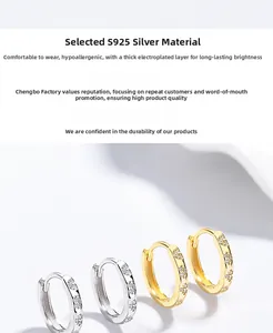 Detail of S925 silver hoop earrings with floral zircon inlays in gold and silver finish