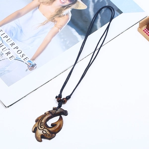 Collana con ciondolo a amo in stile Maori in resina incisa e cordoncino nero