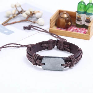 Detail eines Vintage-Lederarmbands mit gravierbarer Metallplatte und Kordelzugverschluss