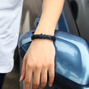 Adjustable woven leather bracelet featuring double black heart arrow design on wrist