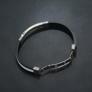 Detail of black silicone men's bracelet with stainless steel clasp and white side stripes