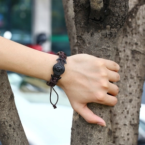 Détail du bracelet en cuir tressé marron foncé avec motif de crâne et ancres
