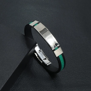 Macro detail of men's silicone bracelet showing green greca pattern and steel buckle
