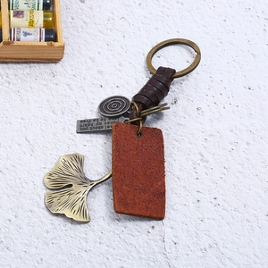 Vintage woven leather keychain with brass rings, ginkgo leaf charm and leather tag