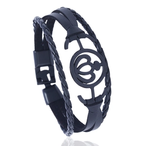 Detail of black multilayer braided leather bracelet with heart metal ornament