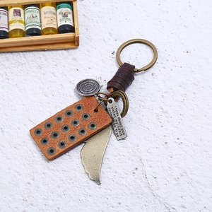 Retro punk keychain with leather strap, metal wing charm, and vintage bronze pendants