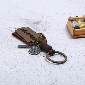Vintage braided leather keychain with antique bronze blade pendant and metal charms