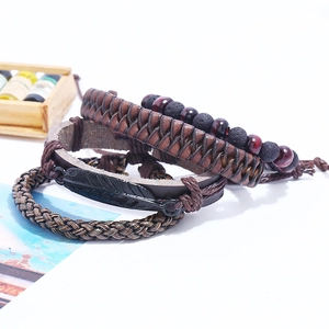 Vintage men's 4-piece set of woven leather bracelets with metal feather pendant detail