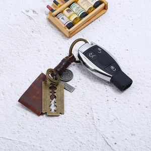 Retro handmade braided leather keychain with bronze blade pendant and engraved metal charm