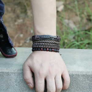 Set of 4 vintage leather bracelets for men featuring a black metal feather and woven cords