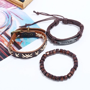 Vintage braided leather bracelet set featuring metal feather charm and wooden beads