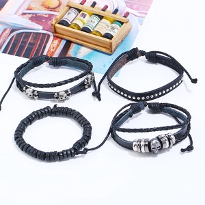 Set of four black punk bracelets featuring skull charms, metal rings and beaded layers