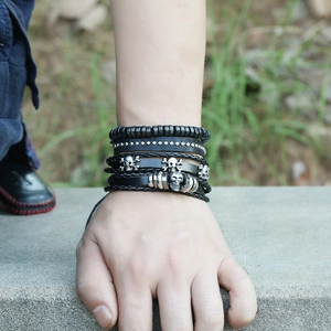 Men's punk multilayer leather bracelet with silver skull charms and black beads on wrist