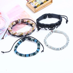 Set of four vintage braided leather and fabric bracelets with bohemian treble clef charm