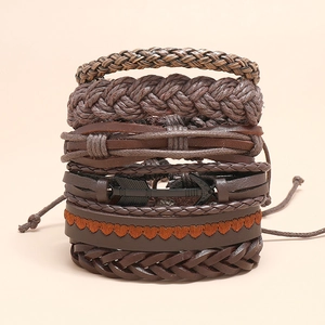 Detail showing vintage layered leather bracelets with woven cords and arrow charm
